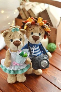 two crocheted teddy bears dressed in clothes and holding flowers, standing next to each other