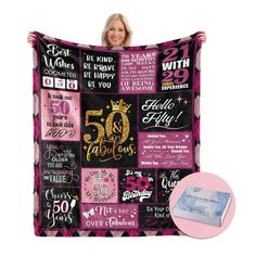 a woman holding up a 50th birthday blanket