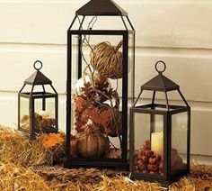 three lanterns sitting on top of hay next to each other