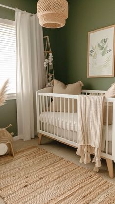 a baby's room with green walls, white crib and beige rugs