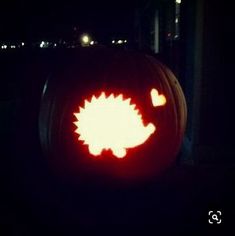 a pumpkin with an image of a hedgehog carved on it's face in the dark