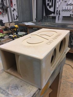 a large white box sitting on top of a wooden table in a garage next to tools