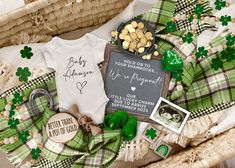 a basket filled with baby items including a shirt, teddy bear and green plaid blanket