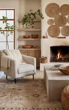 a living room filled with furniture and a fire place in front of a wall mounted fireplace