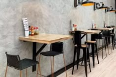 a row of bar stools sitting in front of a wall