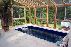 an indoor swimming pool in the middle of a room with glass walls and floor to ceiling windows