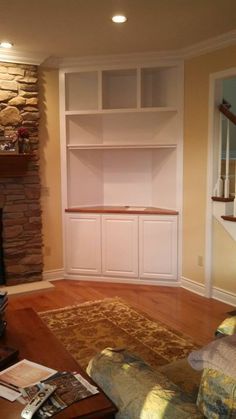 a living room with stone fireplace and built in bookshelves