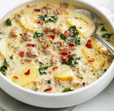 a bowl of soup with meat, potatoes and spinach