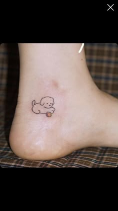 a small tattoo on the foot of a person with a dog and ball in it