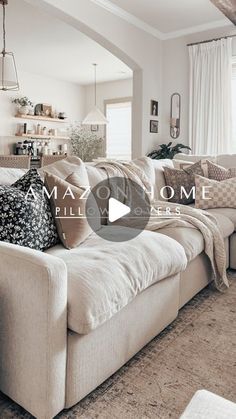 a living room filled with lots of furniture and pillows on top of a white couch