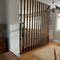 a living room with wooden slats on the wall and wood flooring in front of it