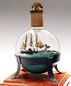 a small boat in a glass ball on a wooden base