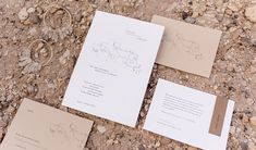 the wedding stationery is laid out on the ground