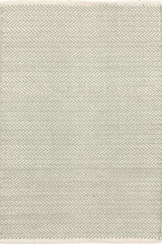 an area rug with white and gray herringbones