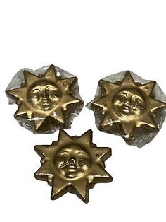 three metal sun and moon buttons with faces on them