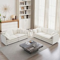 a living room filled with white furniture next to a window