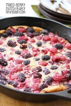 raspberry and cheese pizza in a cast iron skillet on a wooden table