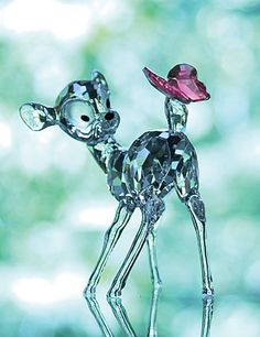 a glass figurine with a pink heart on it's head and legs