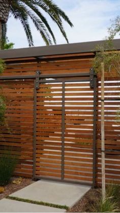 a wooden fence in front of a palm tree