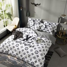 a bed with black and white monogrammed comforters in a bedroom next to a window