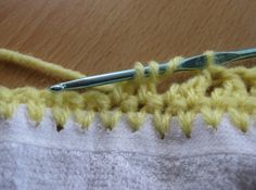 a crochet hook is hooked up to the end of a piece of fabric