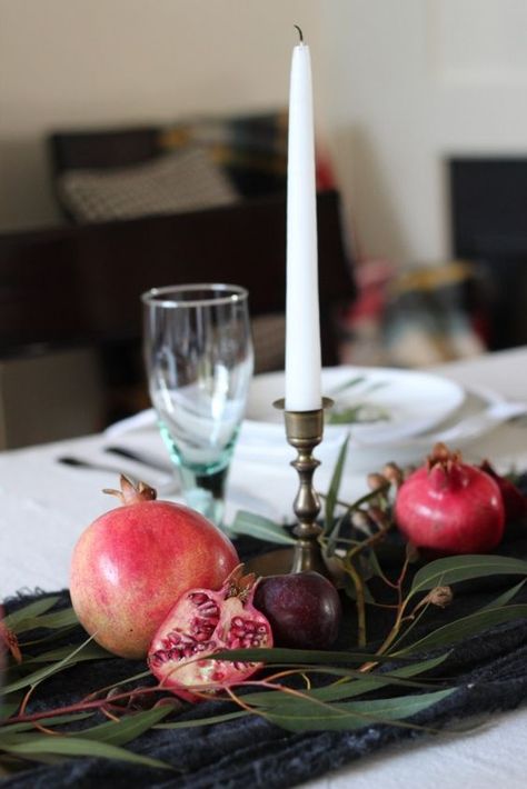 a simple and pretty fall centerpiece of a table runner, greenery, pomegranates and plums plus a tall candle Table Runner Greenery, Pomegranate Wedding, Pomegranate Decor, Fall Home Tour, Winter Fruit, Tall Candle, Red Pomegranate, Dinner Decoration, Rosh Hashanah