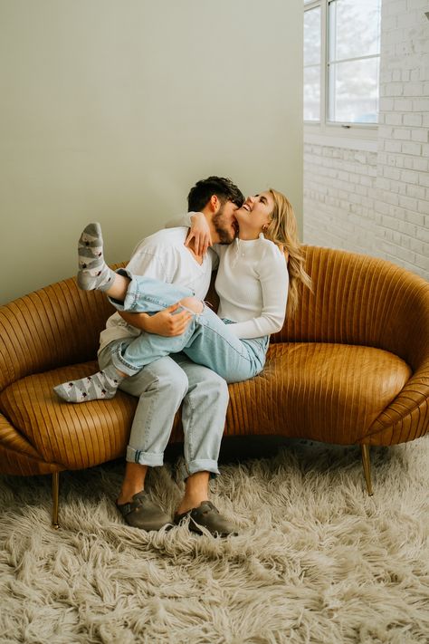 Cute couple laughing on the couch in the studio, couples indoor photoshoot Couple Studio Shoot, Studio Couples Photoshoot, Studio Couple Photoshoot, Engagement Photos Studio, Engagement Studio Photo, Studio Engagement Photos, Indoor Engagement Photos, Cozy Couple, Lifestyle Photography Couples