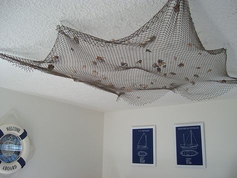 nautical nursery....I like it on the ceiling better than with the name in it on the wall Fishing Net Ceiling Decor, Decoration Theme Marin, Fishing Net Wall Decor, Fish Net Decor, Nautical Home Decorating, Patagonia Shop, Nursery Nautical, Pirate Room, Outdoor Restaurant Design