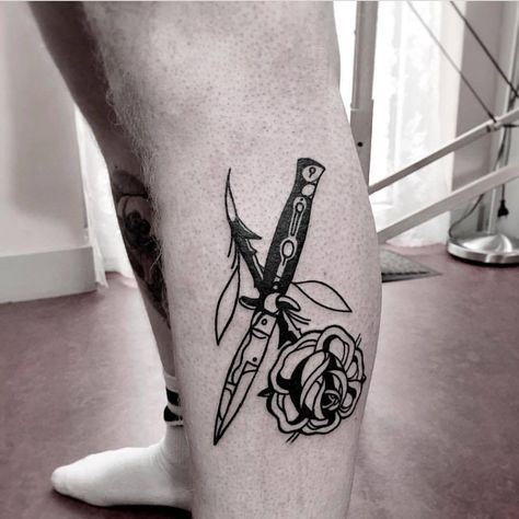 Black switchblade and rose tattoo on the left calf Knife With Rose Tattoo, Switch Blade Tattoo, Knife Through Rose Tattoo, Rose With Swords Tattoo, Dagger Rose Tattoo, Knife And Rose Tattoo, Geometric Rose Tattoo, Rib Tattoos For Guys, Blade Tattoo