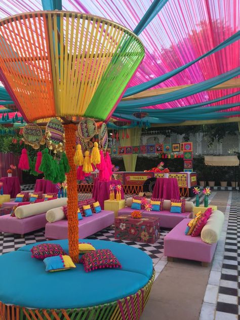 Haldi and Mehndi are the events where you can go quirky and unique with the decor. Carnival theme is all around colour and fun-filled ambience. Vibrant drapes, genda phool and some game stalls brighten up the whole decor done by Abhinav Bhagat Events at Radisson Blu Udaipur Palace Resort And Spa.#indianweddingdecor #weddingDecor #weddingdecorinspiration #decorinspiration #india #carnivalthemedecor #carnivaltheme #weddingdecorideas #decorideas #weddingideas #wedding #decorideasforwedding #mehndi Indian Color Festival, Haldi Decor Ideas, Carnival Wedding Theme, Ambience Decor, Wedding Carnival, Stall Decorations, Mehndi Function, Mehendi Decor Ideas, Haldi Decor