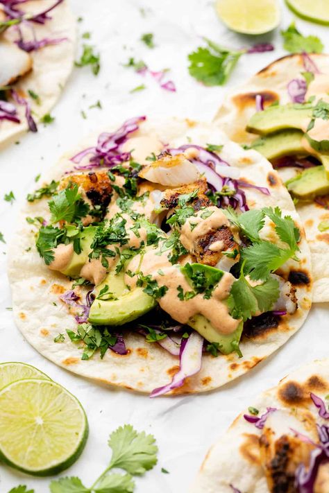 The next time you indulge in Taco Tuesday, mix up the fillings with this delicious Grilled Fish Taco Recipe. Made with cod, lime juice, garlic, and a homemade Greek yogurt sauce, these tacos are savory, tangy, and delightful! Cod Tacos, Taco Night Recipes, Cod Fish Tacos, Fish Taco Recipe, Grilled Cod, Greek Yogurt Sauce, Grilled Fish Tacos, Homemade Greek Yogurt, Fish Taco