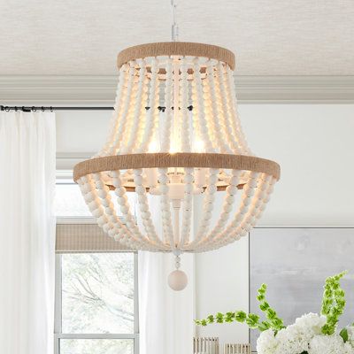 Crafted from metal(white-finished) and wood beads, this fixture features two tiers of rings in the hemp ropes decor for a traditional touch. Strands of oak-white wood beads create a cage and hang below for a splash of glamour. This 3-light statement chandelier brings a glam feel and ambient light to your space. This fixture is height-adjustable, sloped-ceiling adaptable, and dimmer-switch compatible. It accommodates 60W bulbs (sold separately) and complements design styles from bohemian to moder Chandelier Wood, Boho Chandelier, Chandelier Farmhouse, Wood Bead Chandelier, Wood Light Fixture, Gold Ceiling Light, Bedroom Pendant, Rope Decor, Pendant Lighting Bedroom