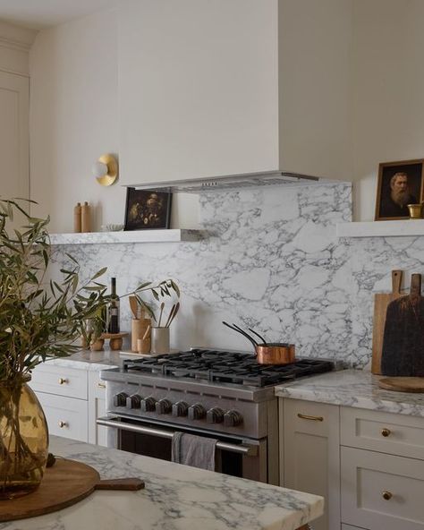 Dreamy transitional kitchen with arabescato marble countertop and modern round wall sconces Marble Shelf Kitchen, Arabescato Kitchen, Arabescato Marble Kitchen, Marble Kitchen Inspiration, Marble Shelves, Modern Shaker Kitchen, Bridge Faucet Kitchen, 1970s Kitchen, Marble Countertops Kitchen