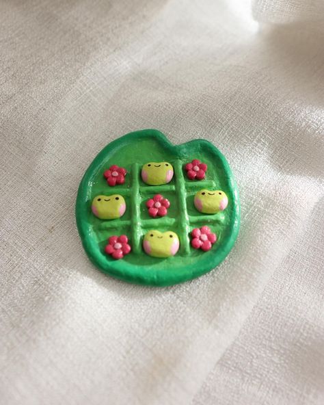 Make game time fun with an Air Dry Clay Tic-Tac-Frog Gift! This adorable DIY project features a playful twist on the classic tic-tac-toe game, perfect as a handmade gift for kids or as a unique addition to family game nights. #ClayCrafts #DIYGifts #TicTacToe #HandmadeToys #CreativeGifts #FunForKids Clay Projects Kids, Dry Clay Crafts, Air Dry Clay Crafts, Tic Tac Toe Diy, Polymer Clay Gifts, Diy Air Dry Clay, Frog Gifts, Air Dry Clay Projects, Clay Crafts Air Dry