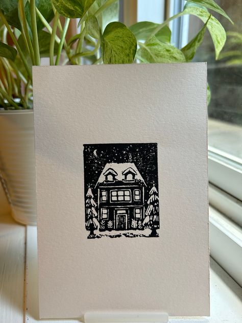 Home for Christmas, this is an original lino print. My favourite Christmas tradition is to watch the movie Home Alone 2: Lost in New York. I wanted to design a family house and imagine all the festivities throughout Christmas day; from picking out a tree, sitting down for dinner, or last minute-gift wrapping. I also wanted to experiment with the contrast of snow and loved how the trees turned out. Print Details - Hand-carved lino printed with Black ink on Fabriano: Print-making Paper (made in It Lino Print Ideas Christmas, Block Printing Christmas Cards, Christmas Linoleum Prints, Winter Lino Print, Christmas Block Printing, Christmas Card Print, Christmas Linocut Prints, Block Print Christmas Card, Christmas Card Lino Print