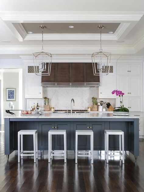 Two Darlana Lanterns hang from a small gray tray ceiling over a blue island fitted with a white marble countertop seating Emeco Counter Stools facing a sink with a satin nickel gooseneck faucet. Unique Ceiling Ideas Kitchen, Ceiling Design Over Kitchen Island, Ceiling Box Above Kitchen Island, Kitchen Tray Ceiling Ideas, Tray Ceiling Above Kitchen Island, Tray Ceiling Over Kitchen Island, Kitchen Island Ceiling Ideas, Ceiling Above Kitchen Island, Range Hood With White Cabinets