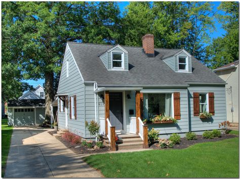 Bungalow renovation with gray siding, wood board and batten shutters, portico and window boxes. Board And Batten Shutters On Siding, Bungalow Shutters, Blue House Cedar Shutters, Blue House Wood Shutters, Gray House With Wood Shutters, House With Cedar Shutters, Light Grey House With Wood Shutters, House With Wood Shutters, Light Blue Siding House Exterior