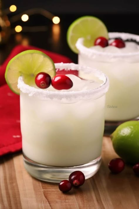 A glass of White Christmas Margarita, rimmed with sanding sugar and garnished with lime slices and cranberries, set against a festive backdrop. Christmas Margaritas, Cranberry Margarita, Sanding Sugar, Silver Tequila, Festive Cocktails, Christmas Cocktail, Winter Cocktails, Christmas Food Dinner, Drinks To Try