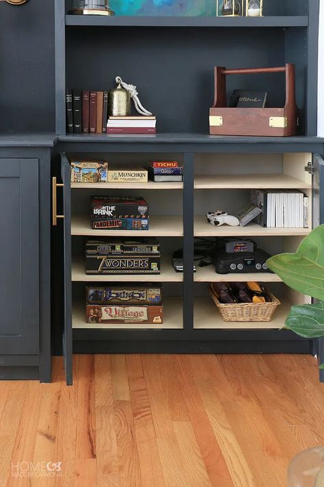 DIY built-in cabinets create additional storage | Home Made by Carmona | #storage #builtins #builtinbookshelves #gamestorage #diy #bookcases #blackbookcases #diybookcases Built In Board Game Storage, Board Game Cabinet, Game Storage Cabinet, Board Game Storage Cabinet, Board Game Storage Ideas, Game Storage Ideas, Diy Bookcases, Video Game Cabinet, Builtin Bookshelves