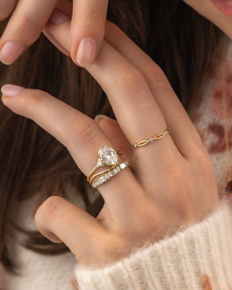 WHICH BAND WOULD YOU CHOOSE? We've styled our antique-inspired Lady's Slipper Ring with five wedding band options. 1. Curved Trio Band and Constancy Band 2. Rose cut diamond Plenilune Band 3. Curved Pairing Band and Prelude Band 4. Chevron Wisp Band 5. Curved Tinsel band Styling tip: When styling an engagement ring with a low basket setting that doesn't allow a band to slip underneath, add a simple band that has a customized curve to wrap around the engagement ring. Then add your favorite... Wedding Band Vs Engagement Ring, Curved Wedding Ring Stack, Curved Wedding Band Oval Engagement Ring, Contour Wedding Band With Oval Ring, Curved Wedding Band With Engagement Ring, Wedding Band With Oval Engagement Ring, Wedding Band Stack, Curved Wedding Ring, Infinity Wedding Band