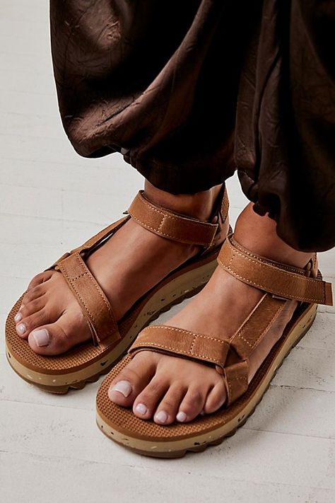 Taking cues from other iconic Teva styles, these heritage-style sandals feature leather hook-and-loop straps and an extra-cushy, double layer sole with speckled details and tread accents. **Features:** Slip-on style, hiker-inspired design, supple leather uppers, Universal Strapping System™, leather lining, hook-and-loop closure, molded EVA midsole with heel cupping and arch support, rubber sawtooth outsole, speckled details, treated with Life Naturals for antimicrobial benefits **Why We | Teva U Shoes Design Ideas, Teva Style, Camila Morrone, Teva Sandals, Surfer Style, Brown Fits, Shoes Design, Hiking Sandals, Ideas For Wedding