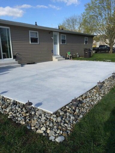 Rock Borders Edging Around Patio, Rock Around Patio Ideas, Concrete Patio With Rock Border, River Rock Around Concrete Patio, River Rock Around Patio, River Rock Patio Border, Rock Around Deck, Rock Border Around Concrete Patio, Easy Rock Landscape Ideas