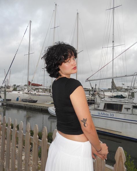 Short hair, black hair, betty boop hair, outfit inspiration, white skirt, long skirt, black shirt, tattoo, photo inspo, instagram inspo, woman standing in front of boats Betty Boop Inspired Hair, Betty Boop Haircut, Betty Boop Hair, Short Hair Black Hair, Betty Boop Tattoo, Short Hair Inspo, Photo Inspo Instagram, Hair Black Hair, People References