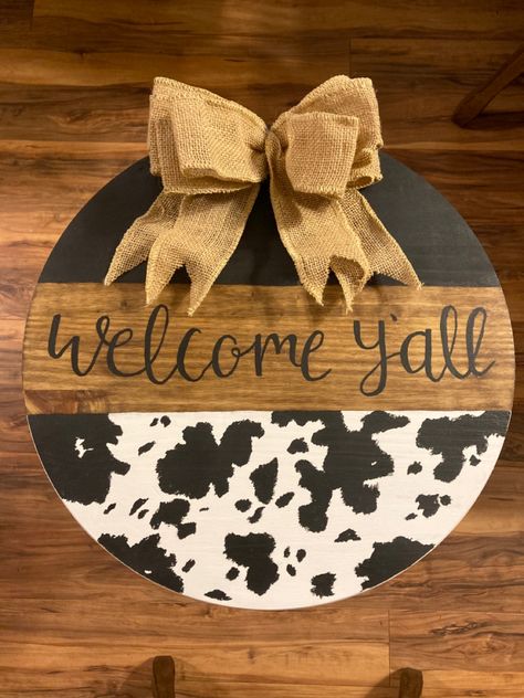 Cow Print Cricut Projects, Western Door Hangers Wood Signs, Cowhide Door Hanger, Cow Welcome Door Hanger, Round Welcome Sign Front Door Diy Ideas, Cow Print Door Sign, Circle Door Hangers Wooden Diy, Western Door Hangers, Cow Wreaths