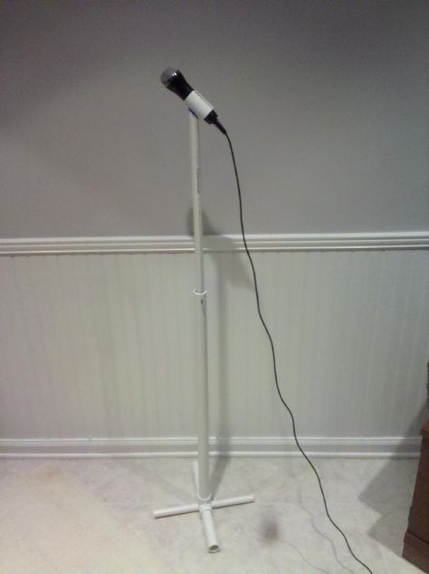 Built this simple microphone stand out of PVC for use with our Rock Band microphone.  Hopefully pretty self explanatory from the pics. We cut the top vertical tube on a diagonal and then wrapped sandpaper around the mic holder to sand the proper curve into the top of the vertical tube.  Used PVC glue to glue it.  This is the only glued joint. For the base, we drilled a hole in the T-joint to fit the cross-piece.  The hole was tight enough that we didn't need to glue the c... Diy Mic Stand, Diy Microphone, Dance Team Gifts, Pvc Decking, Pvc Pipe Crafts, Pvc Pipe Projects, Microphone Stands, Pvc Projects, Mic Stand