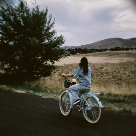 girl riding blue bike with basket on the street with mountain scenery Aesthetic Bikes With Basket, Bike Pictures Aesthetic, Riding A Bicycle Aesthetic, Bike With A Basket, Blue Bike With Basket, Woman On Bicycle, Bike Riding Astethic, Bike With Basket Aesthetic, Bike Asthetic Picture