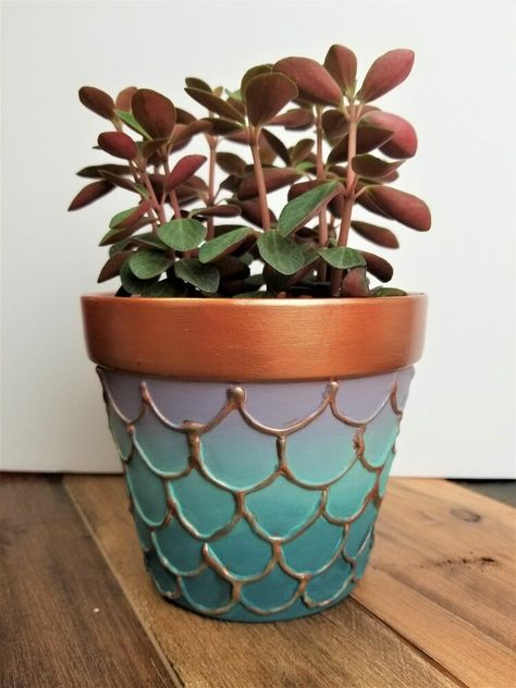 Learn how to make your own DIY mermaid flower pots with Texture Powder, Metallic Cream, and All-in-One Decor Paint!  Step OneSeal the inside of your unpainted terracotta pot with Tough Coat to prevent dirt, moisture and contaminants from leaching through and staining your work. You can opt for Clear Coat instead of Tough Coat with 3-4 coats.NOTE: the outside of the pot does not need to be painted! We were re-using a pot that had already been painted, but the plain terracotta finish is… Fun Planters, Diy Mermaid, Potted Christmas Trees, Country Chic Paint, Mosaic Flower Pots, Painted Pots Diy, Painted Plant Pots, Pot Crafts, Painted Terra Cotta Pots