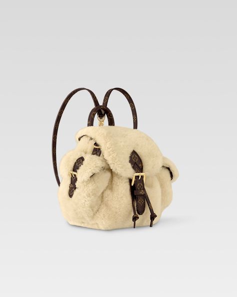 Perfect for an alpine escape, this Nano Teddy Backpack from the LV Ski collection has a luxurious yet cozy feel. Crafted from cream shearling, it is trimmed with signature Monogram canvas and accented with a sleek gold-toned buckle. The statement style is fitted with two side pockets and is roomy enough to store a phone and wallet, plus any other small essentials. #leaguefits #louisvuitton #louisvuittonbags #louisvuittonbag #louisvuittonaddict #louisvuittonlover #lvcommunity #lvworld #leagu... Ski Essentials, Teddy Backpack, Color Crema, Louis Vuitton Official, Buckle Shoes, Monogram Bag, Silver Jewelry Fashion, Luxury Watches For Men, Fashion Jewelry Necklaces