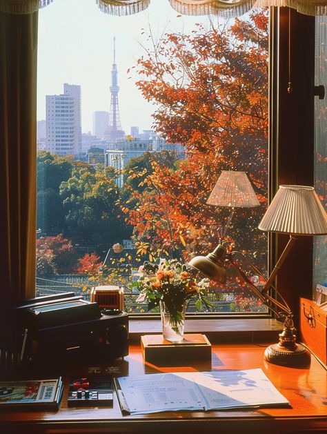 🍂✨ Step back in time to a luxurious living room in 1980s Tokyo! Imagine lounging in a high-class apartment with stunning views of vibrant maple leaves and the iconic Tokyo Tower. From the vintage wooden desk adorned with a lamp and old telephone to cherished comics and video games, every detail whispers nostalgia. 🌸📞 The warm glow of natural light on Kodak film captures the cozy atmosphere perf... Tokyo Fall Aesthetic, Living In Tokyo Aesthetic, Japanese Old Money, Desk By Window, Desk Under Window, Japanese Apartment Aesthetic, Tokyo Luxury, Japan Apartment, Tokyo Apartment