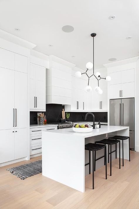 White kitchen cabinets feature oil rubbed bronze pulls, black soapstone slab backsplash and a shiplap range hood. Soapstone Backsplash, Shiplap Range Hood, Black Soapstone Countertops, Black Soapstone, Black Kitchen Handles, Collective Studio, White Shaker Kitchen Cabinets, White Shaker Kitchen, Soapstone Countertops